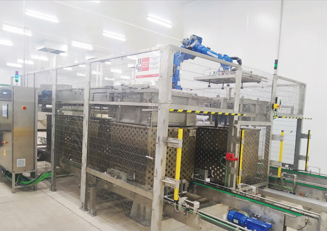 Foto Solución de encestonado y desencestonado de latas en carros para autoclave con robots Yaskawa realizada por DGH Robótica para la empresa de conservas Hijos de Carlos Albo.